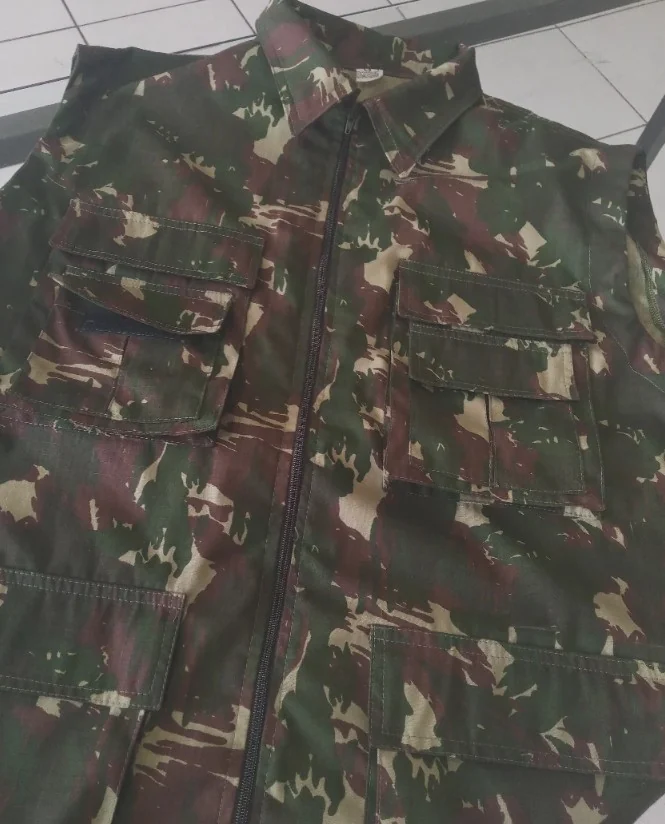 Jaqueta de fardamento camuflado exibindo costuras, fechamento e bolsos
